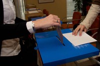 Una membre del personal de la UPC introdueix un sobre electoral dins d'una de les urnes de les votacions del 20 de febrer